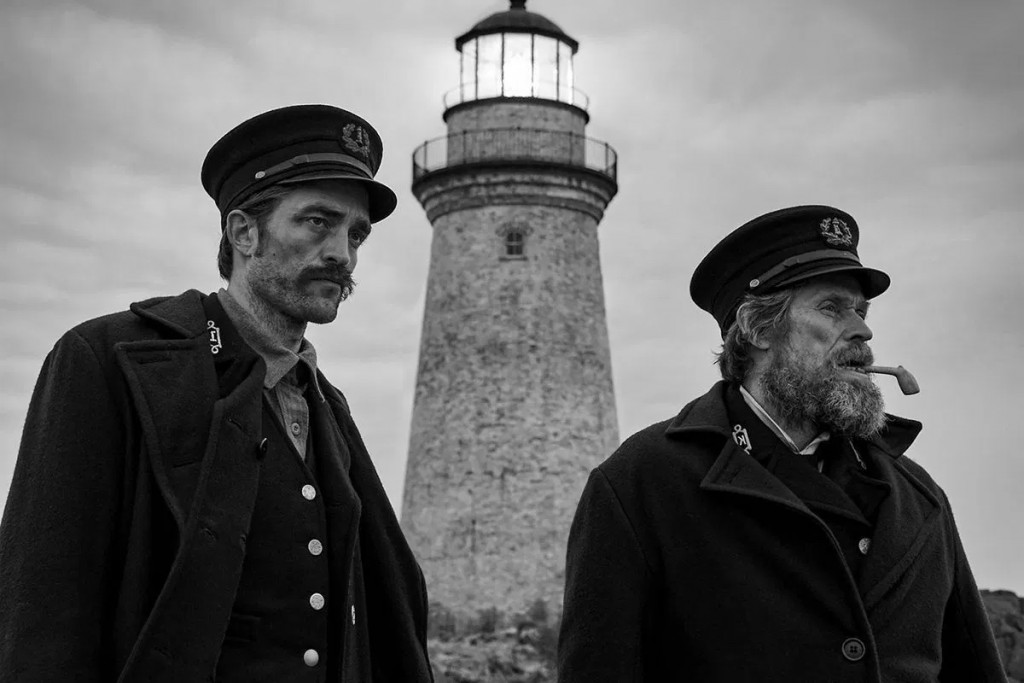 Ephraim Winslow (Robert Pattinson), the lighthouse (phallic symbol), and Thomas Wake (Willem Dafoe) stare out into the sea.